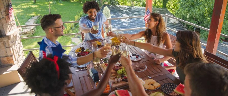 group of young adults sitting around a table making a toast