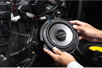 Technician installing custom or factory-integrated car audio speaker system