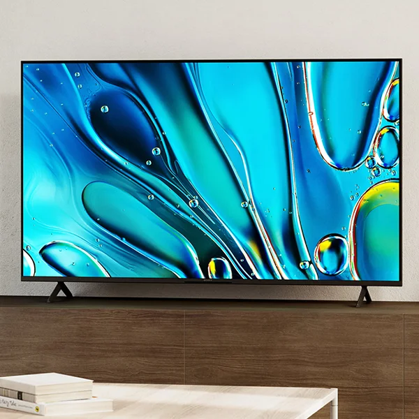 The Sony Bravia 3 TV sitting on a wooden TV stand displaying a textured blue image.