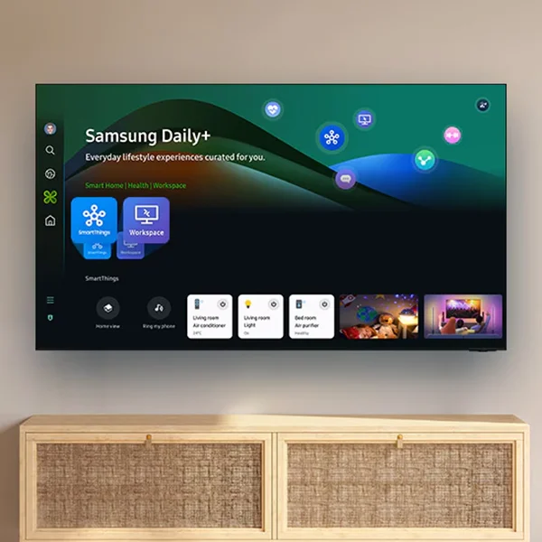 The Samsung Q60D TV mounted on a wall displaying the Samsung Daily+ home menu.