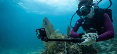 A woman scuba diving with the HERO13 on a mount
