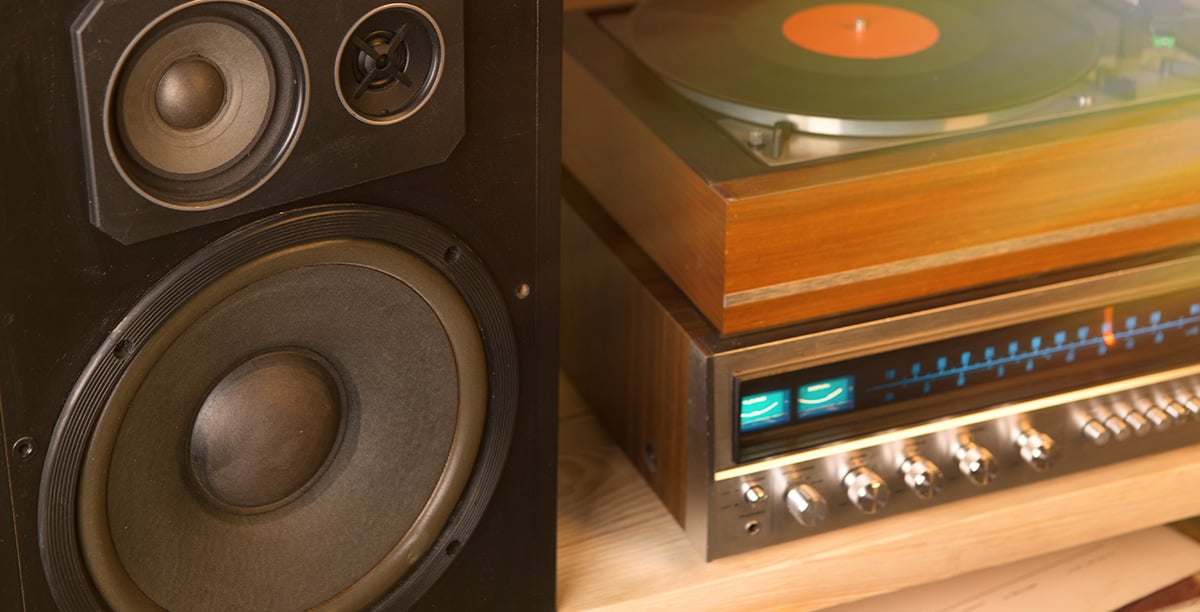 A zoomed-in photo of a large speaker beside a turntable and receiver