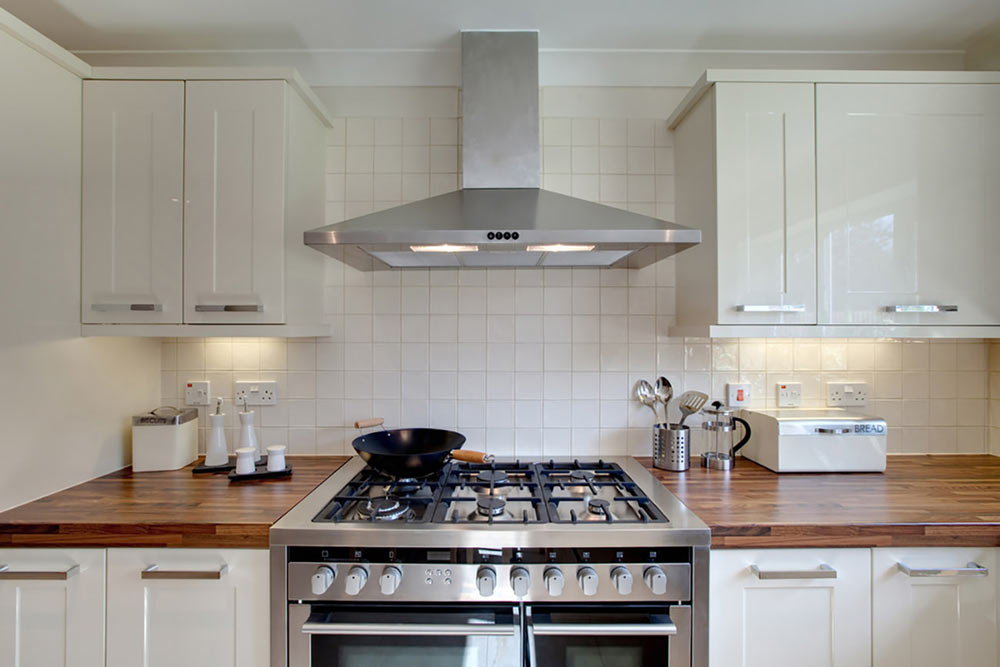 Inside of kicthen with gas top oven and hood