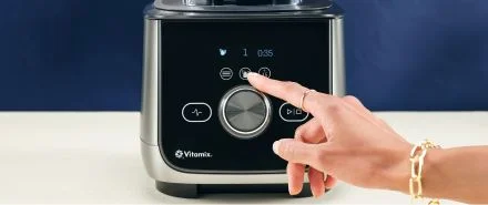 A close-up of the Vitamix Ascent X4 and a person spinning the dial