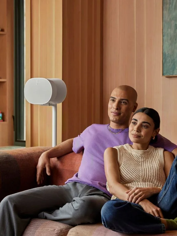 Close up on a person holding an apple TV remote showcasing him turning on the apple tv to watch