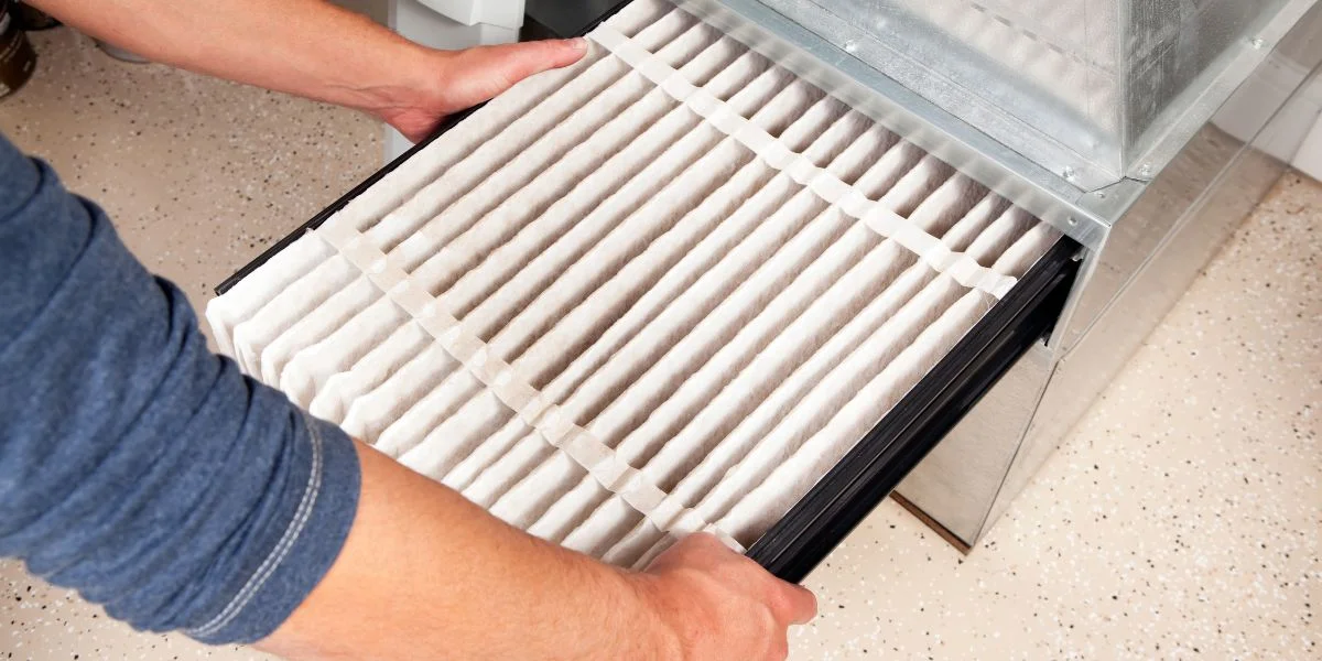 A person replacing their furnace filter