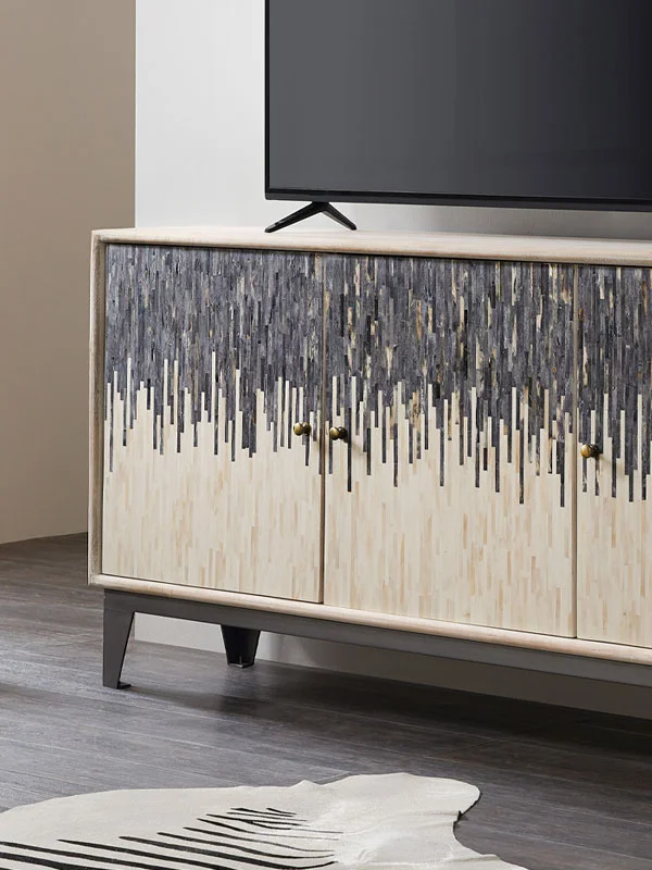 TV on a stylish media stand with home theater speakers and decor in a modern living room