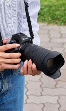 Person holding the new tamron lens 18-300mm on the nikon z and taking a photo