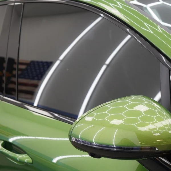 A green sports car in the Abt window tinting bay