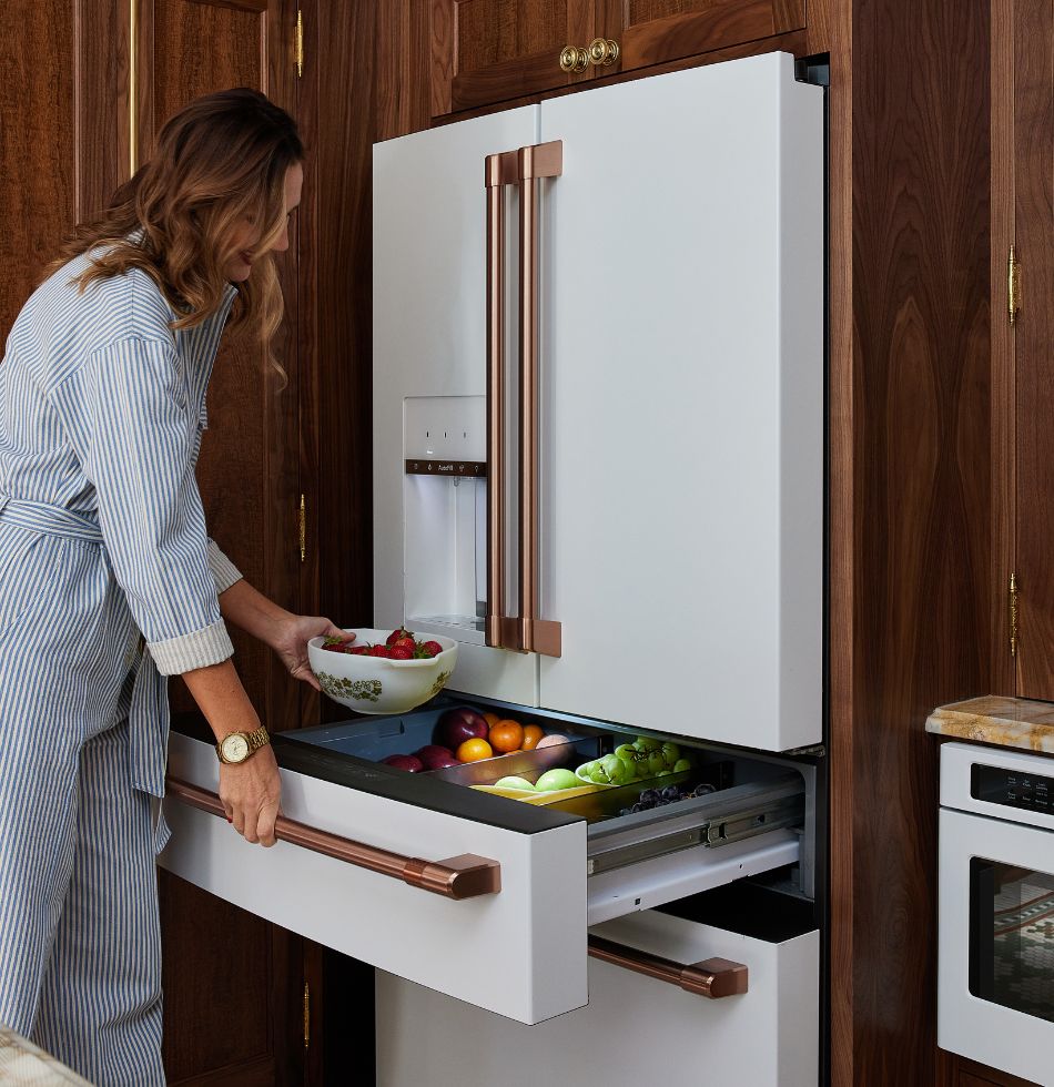 Crystal is opening her refrigerator door, revealing a glimpse of the contents inside