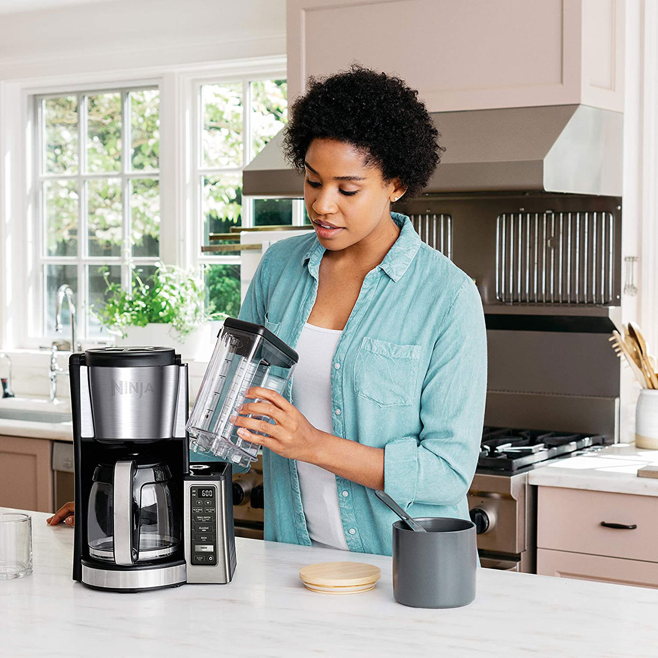Woman Cleaning Ninja Coffee Maker in Kitchen