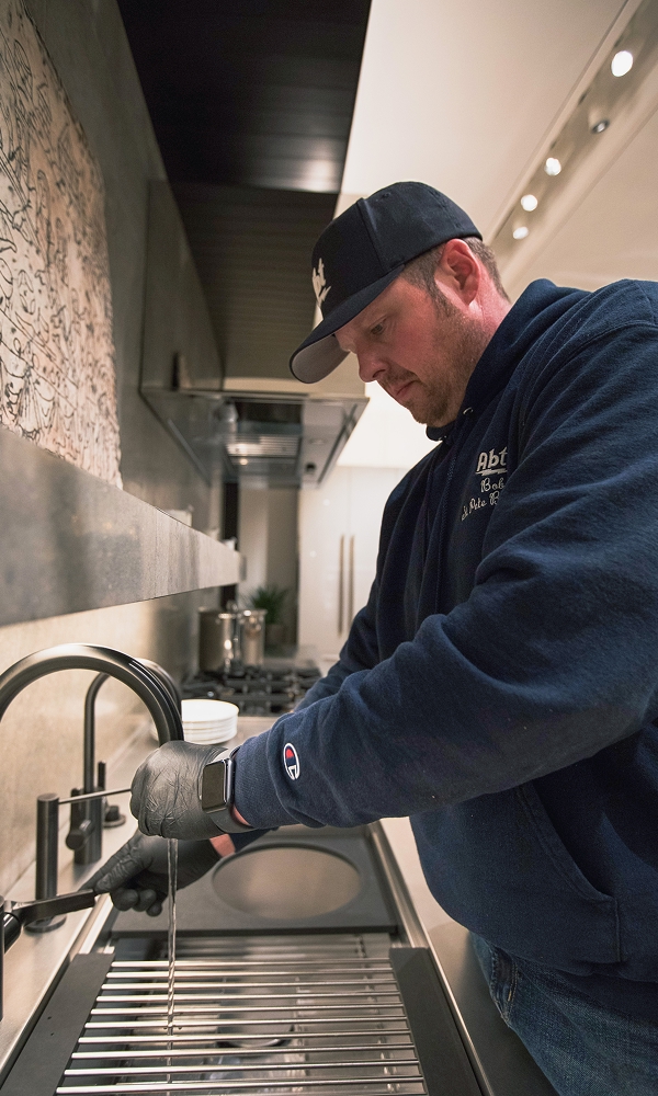 Abt Plumber working on a faucet