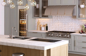 Interior view of kitchen with island sink, range and hood.