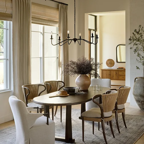 A dining room featuring a wooden table surrounded by four chairs, with soft lighting creating a warm atmosphere.