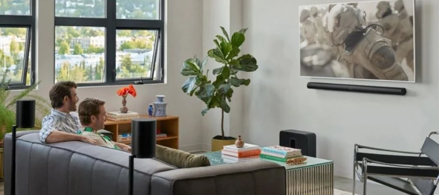 Two men on the couch watching TV with the Sonos Sub 4 and Sonos arc ultra