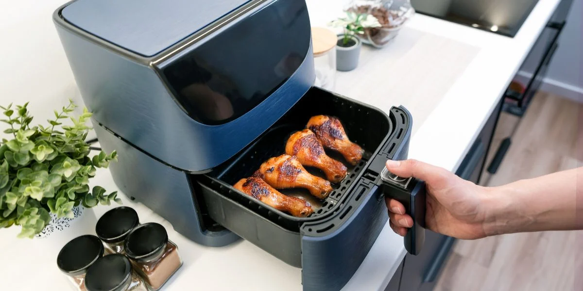 Four crispy wings fryer to perfection in a black air fryer.