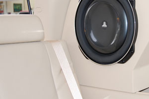 A white interior backseat of a car with a subwoofer installed