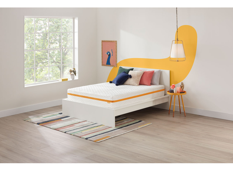 White bed with yellow accent wall art and scatter cushions in a bright bedroom setting, showcasing a clean contemporary bed frame.