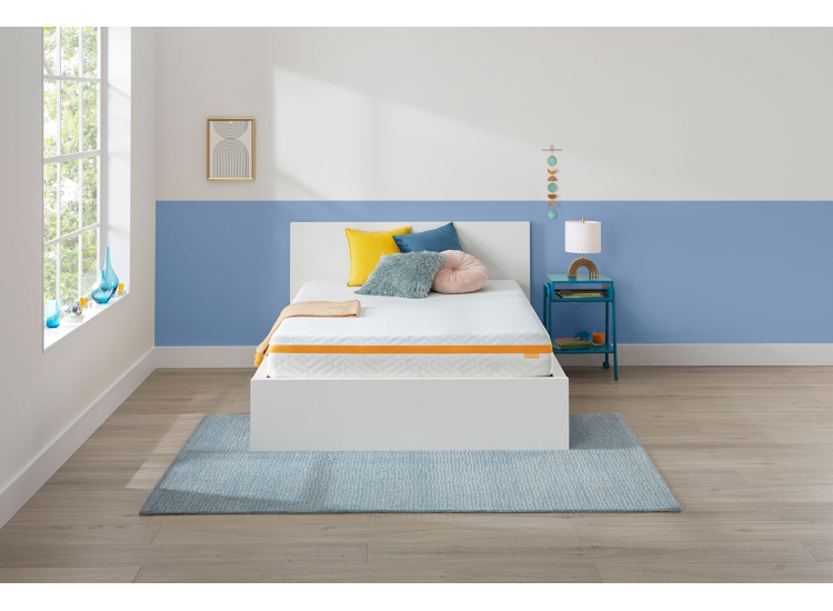 White modern mattress with a bold orange stripe, showing edge detail and logo tag, placed in product shots