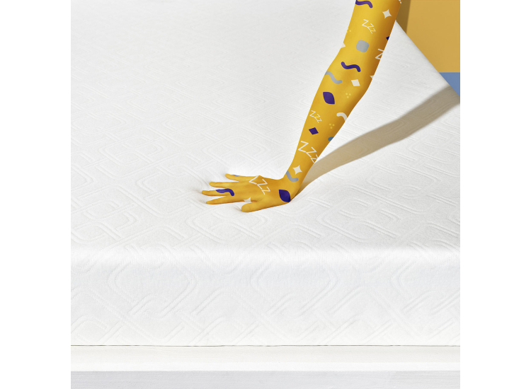 Close-up of a white textured mattress cover on a bed, with visible patterning along the surface and a yellow tag.