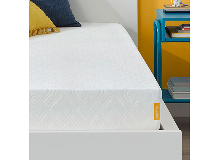 Close-up of the mattress edge on a bed, showing the embossed pattern and fabric texture.