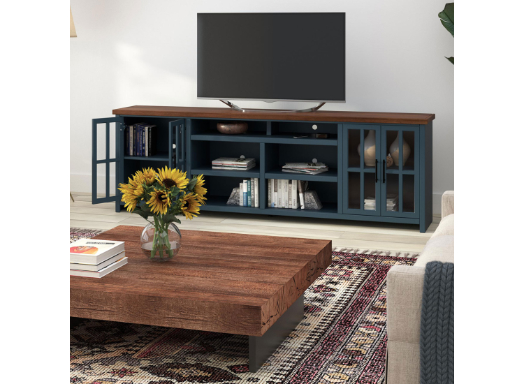 A blue and brown TV stand with glass doors and shelves in a living room