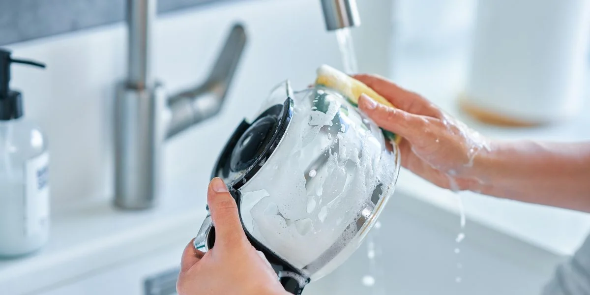 Cleaning a coffee carafe within a sink