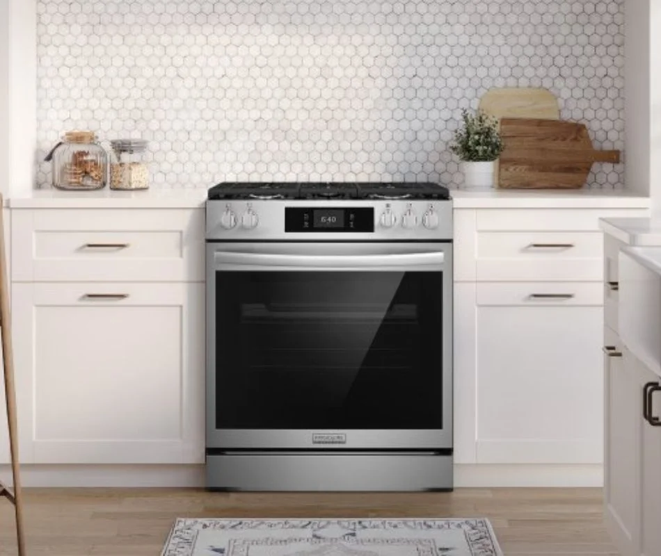 Frigidaire Gallerys new range with pizza ready section the range is open showing the built in pizza compartment with pizza cooking on the pizza plate