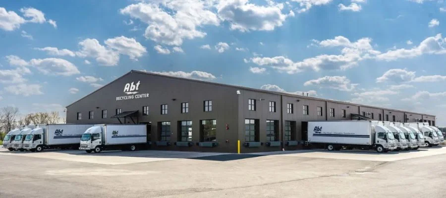 abt recycling center with Abt trucks in bays against a cloudy blue sky