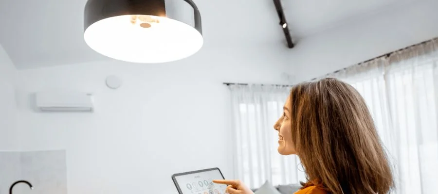 A woman controlling her lights on a tablet.