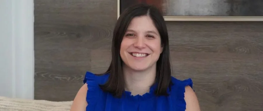 A close-up of Beth Shapiro smiling in front of a painting