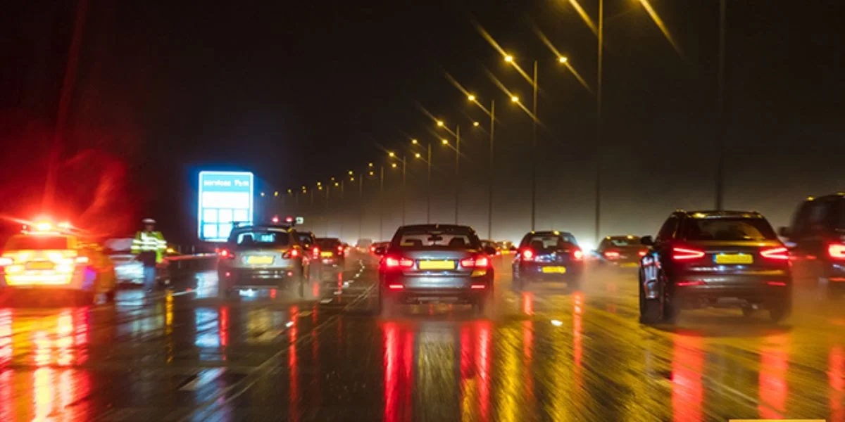The view from a dash camera at night as the driver moves through a dark, rainy highway.