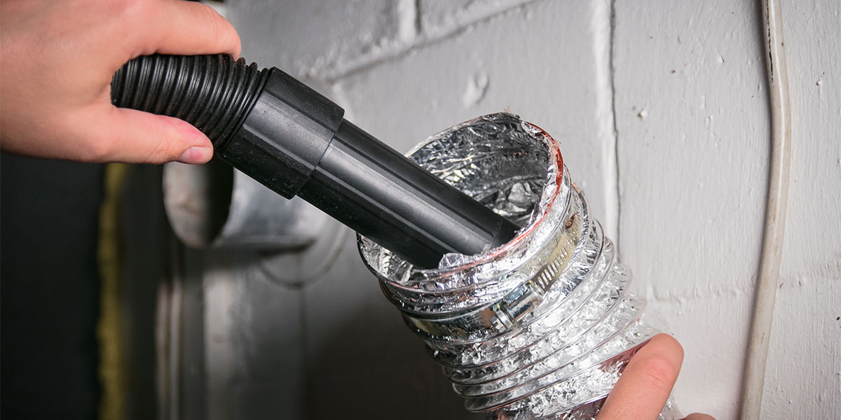 Person vacuuming out dryer hose.