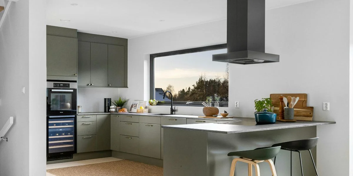 An island hood installed in a compact, modern kitchen.