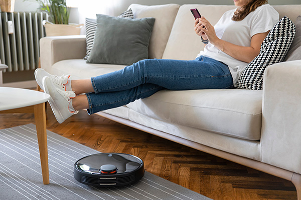 Robot Vacuum Cleans as Woman Relaxes