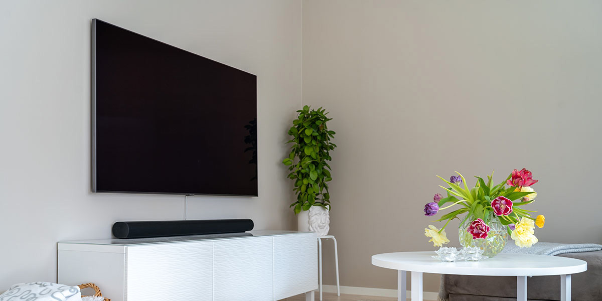 Room with a TV mounted on the wall with a soundbar sitting below
