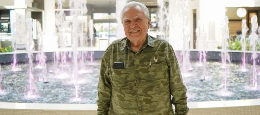 Leonard Jablon wearing his military uniform and smiling in front of Abt's atrium fountain for the Customer Appreciation Sale