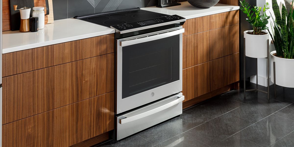 Angled view of an electric GE Profile range with controls on top in a kitchen