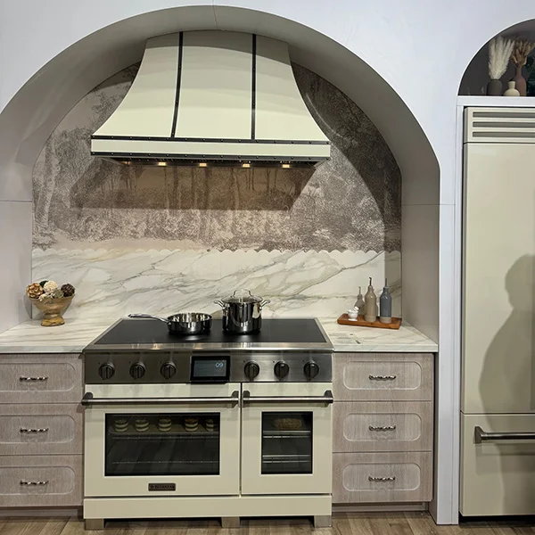front angle of a cream BlueStar induction range with matching range hood