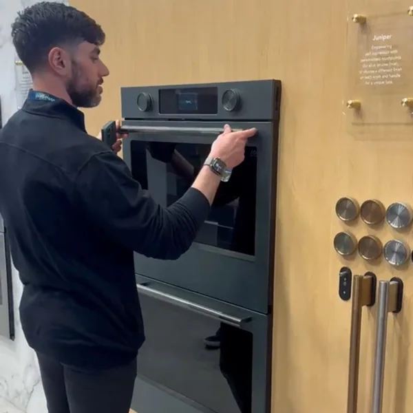 man putting a handle on a double oven
