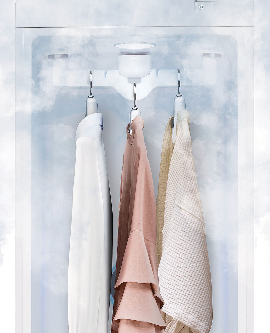 Front view of clothes on hangers with steam