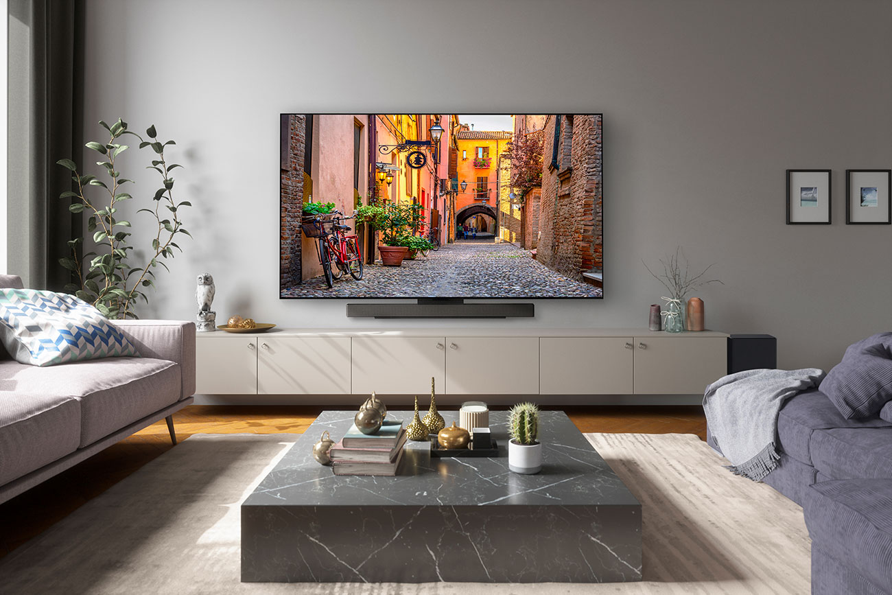 OLED TV in a Living Room with LG 3.1.3 Channel Sound Bar and Subwoofer Installed Underneath and to the side