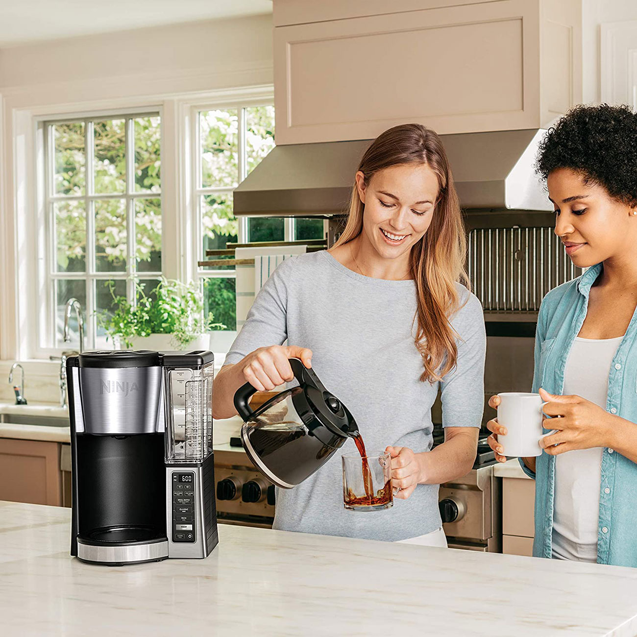 Woman Serving Coffee by Ninja Coffee Maker in Kitchen