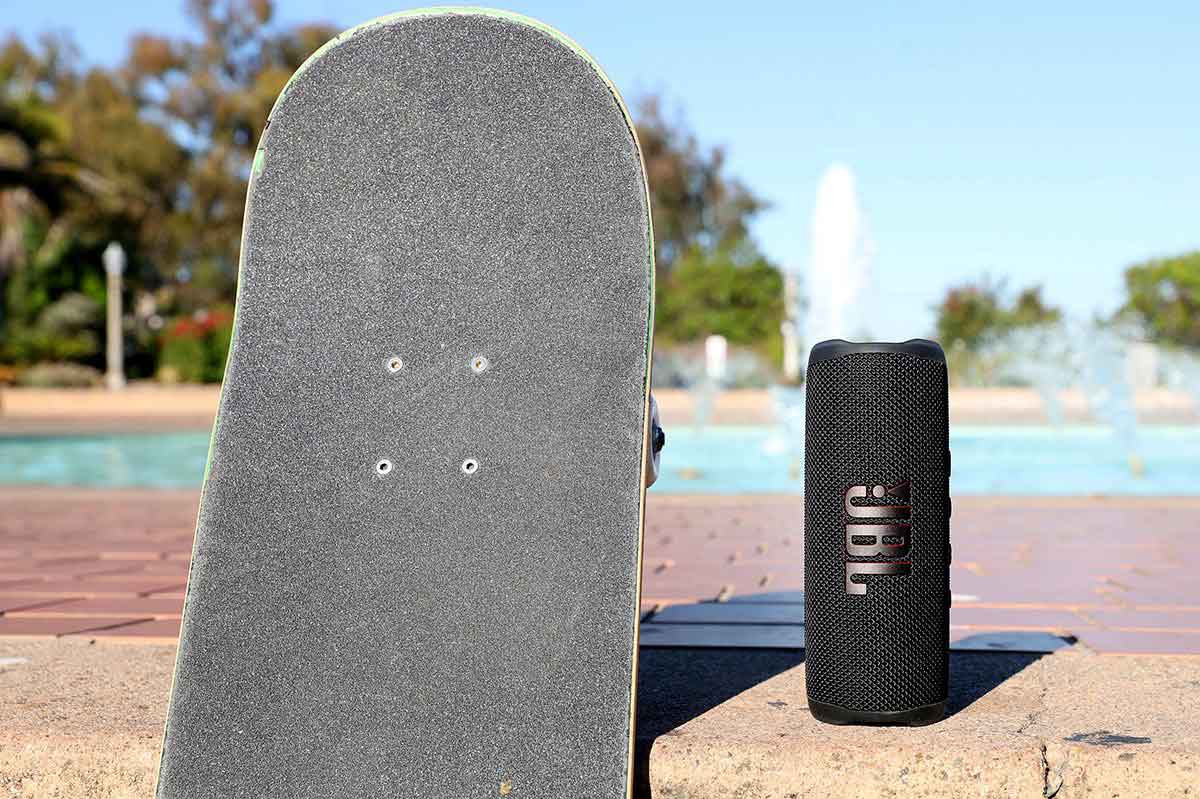 Bluetooth Speaker beside a skateboard outside