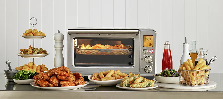 The Breville The Smart Oven Air Fryer Pro surrounded by air fried snacks