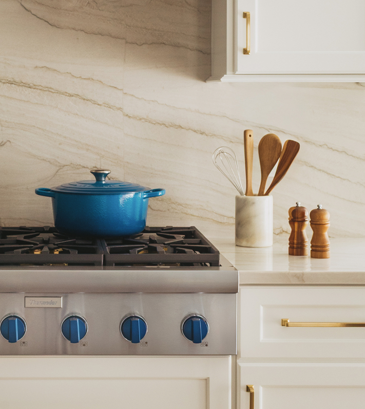 Detailed view of a Thermador stove with distinctive blue knobs, highlighting the appliance's premium features and accessories