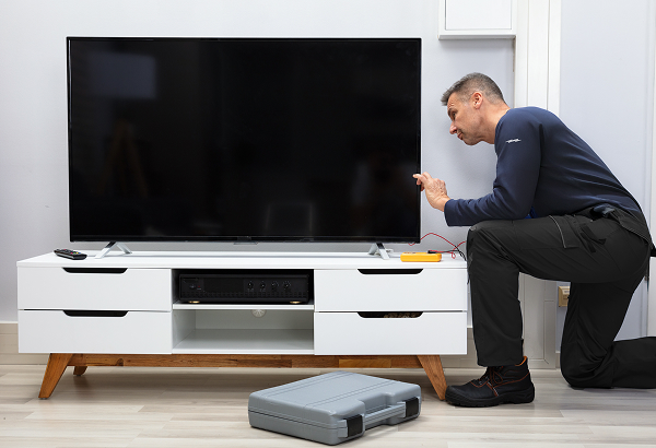 A technician inspecting a television