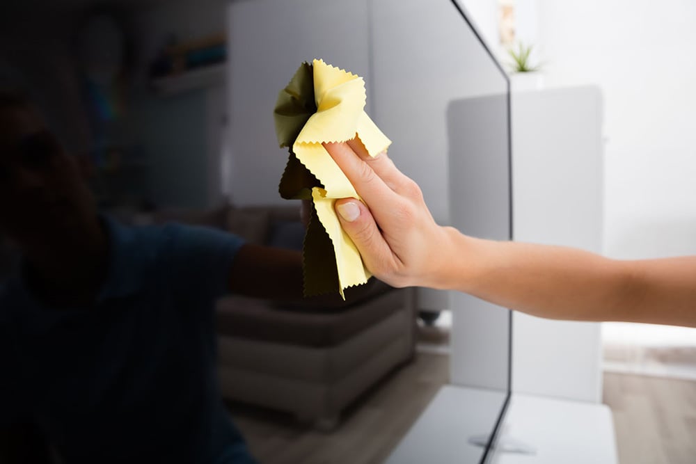 Person cleaning a TV screen
