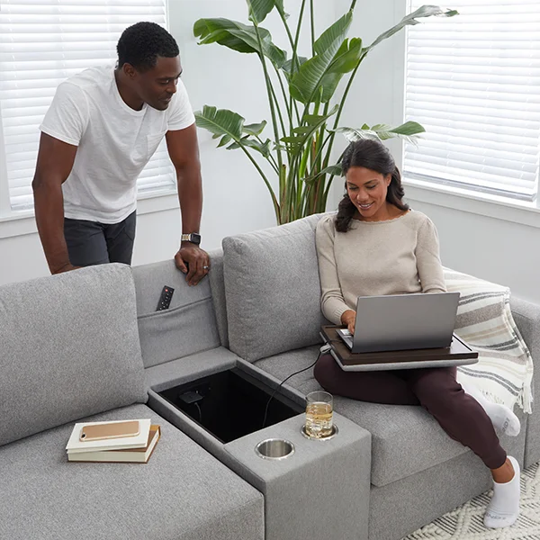A couple hanging out on a sectional with an open middle console