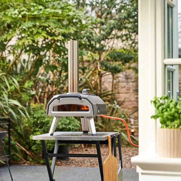 A pizza oven sitting on a small table outside